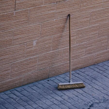 wooden broom on the wall on the street