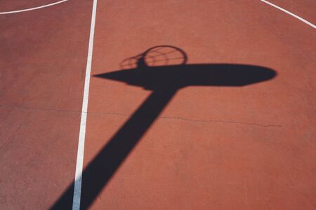 basketball hoop shadow silhouette on the red court on the streetの写真素材