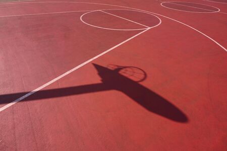 basketball hoop shadow silhouette on the red court on the street