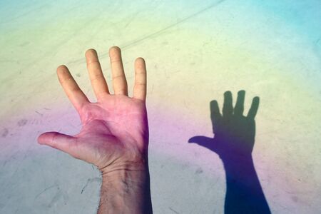 man hand gesturing on the blue wall on the streetの写真素材