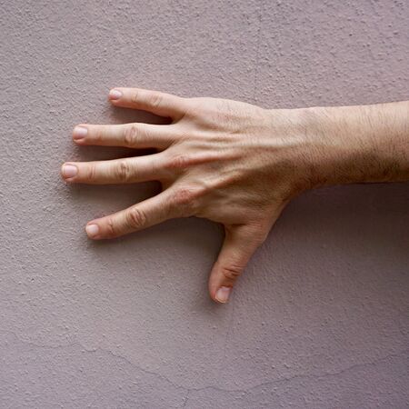 man hand gesturing on the pink wallの写真素材