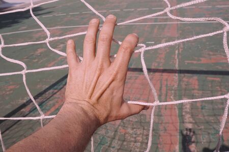 man hand grabbing the rope netの写真素材