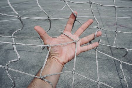 man hand grabbing the rope net