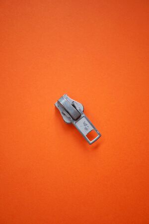 metallic zipper on the orange backgroundの写真素材