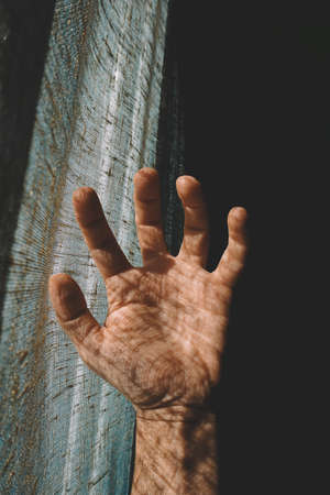 man hand in the shadows feeling the sunlightの写真素材