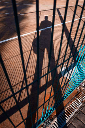 man photographing his shadow on the groundの写真素材