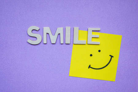 smile word with wooden letters on the purple backgroundの写真素材
