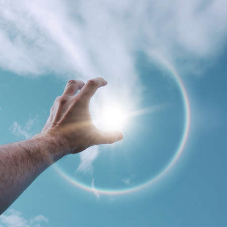 hand in the air playing with the sunlightの写真素材