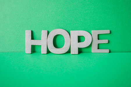hope word with wooden letters on the green backgroundの写真素材