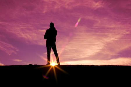 man trekking in the mountain with a sunset background in summertimeの写真素材
