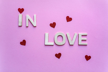 in love word with wooden letters on the pink background, valentine's dayの写真素材