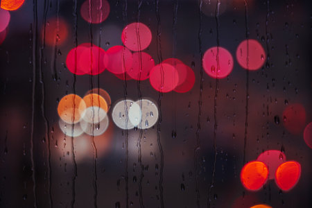 raindrops on the window in rainy days and street lights backgroundの写真素材