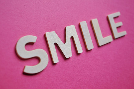 smile word on the pink background, feelings and emotions