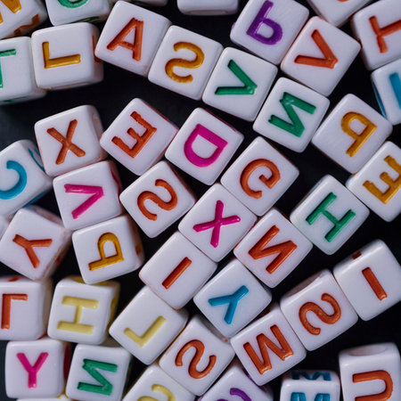 Colorful plastic alphabet blocks with letters of the English alphabet on black background