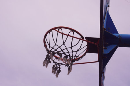 Basketball hoop with ball and net on blue sky and white cloud backgroundの写真素材