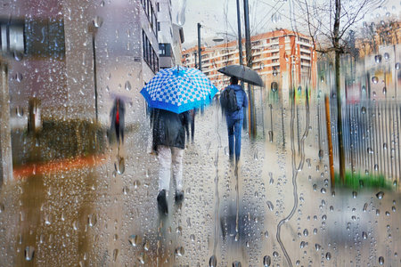 Rainy day in the city. People are walking in the rain.の写真素材
