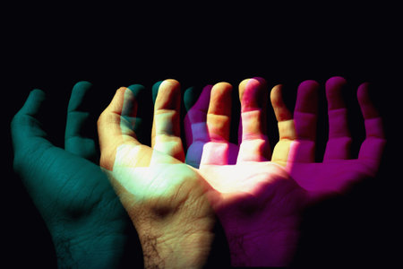 Hands of a man and a woman with different colors on a black backgroundの写真素材