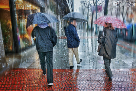 People walking in the rain with umbrellas on a rainy dayの写真素材