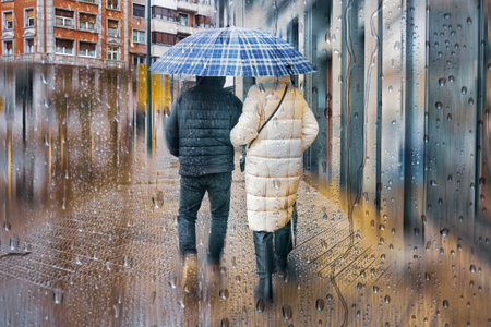 couple in winter clothes walking through the rain on a rainy day