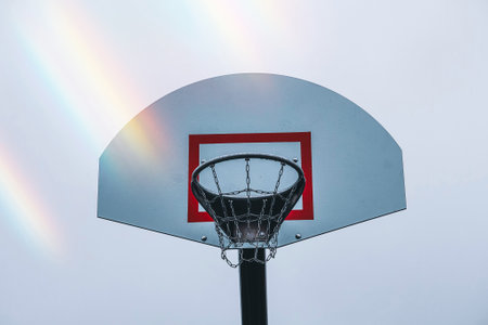 Basketball hoop on a street basketball court against the background of the rainbowの写真素材
