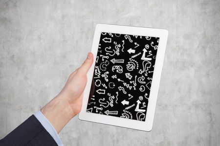 Hand holding Tablet Computer with arrowsの写真素材