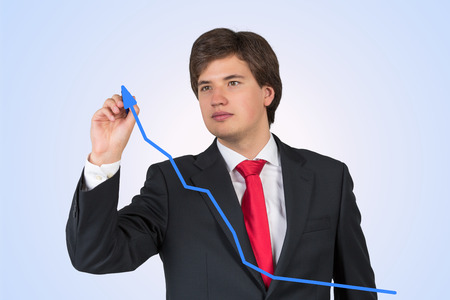 businessman drawing chart on a blue backgroundの写真素材