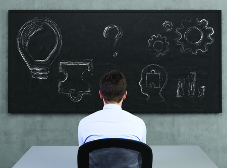 businessman sitting in office and looking to drawing symbol on deskの写真素材