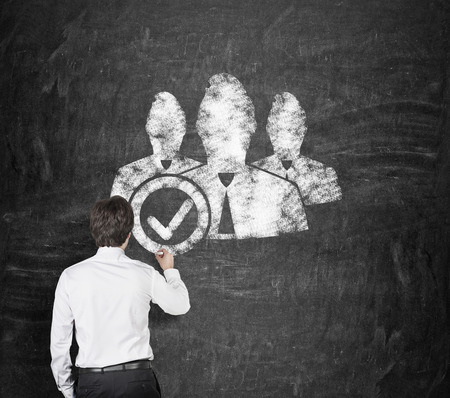 businessman in room drawing employeron on blackboardの写真素材