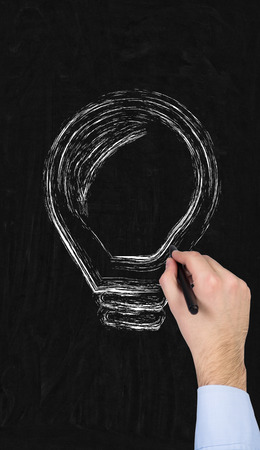hand drawing lightbulb on blackboardの写真素材