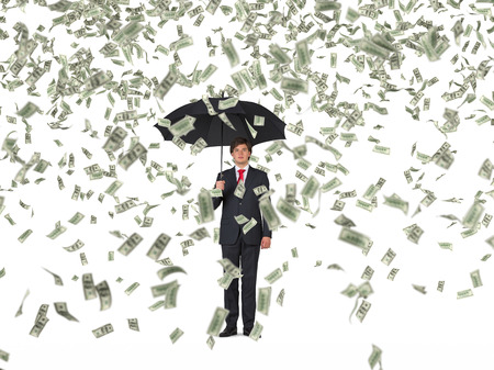 businessman standing with umbrella and falling dollarsの写真素材