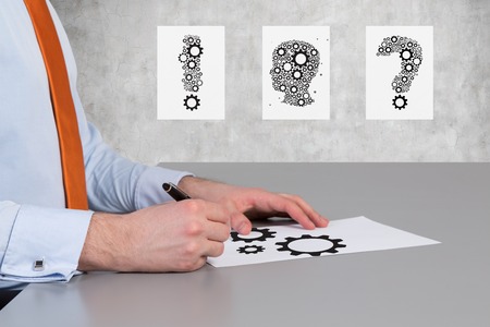 businessman drawing gears symbol on desk