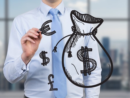 businessman standing in office drawing money bagの写真素材