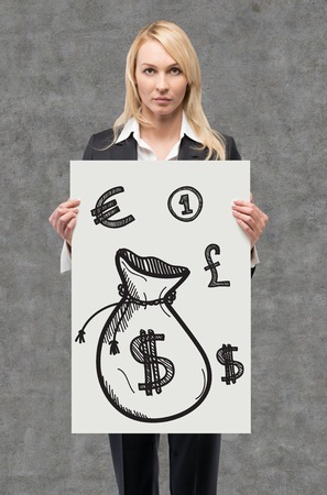 businesswoman holding placard with drawing money bagの写真素材