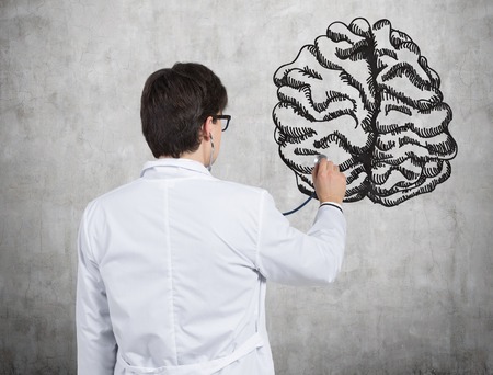 Doctor examines brain drawing on wallの写真素材