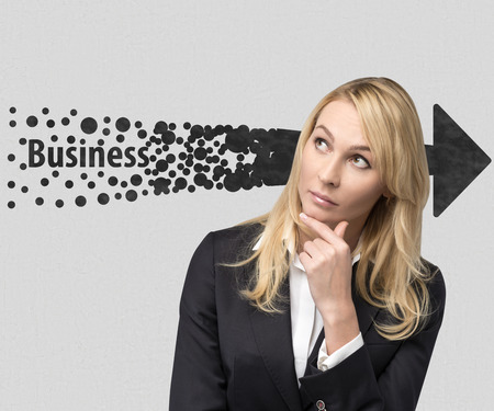 businesswoman thinking and drawing arrow on wall