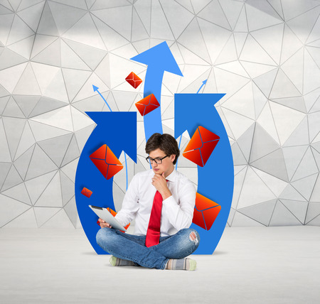 young businessmen sitting with tablet and sends emailの写真素材