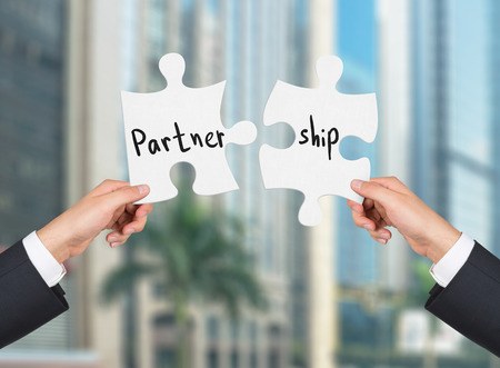 two hands holding puzzle drawing partner and shipの写真素材