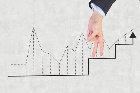 fingers walking on graphs drawing on wallの写真素材