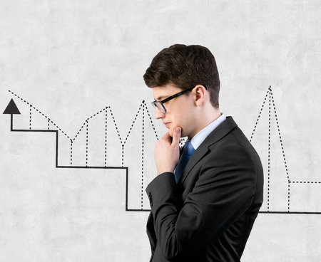 businessman thinking and charts drawing on wallの写真素材
