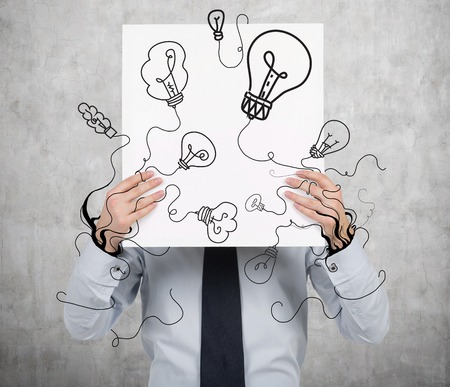 businessman holding poster with drawing lamps
