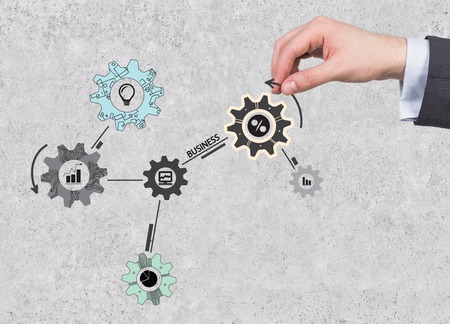 hand holding cogs and gears on wall の写真素材