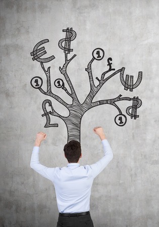 happy businessman with money tree over headの写真素材
