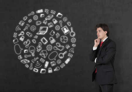 businessman looking on media icons in form earthの写真素材