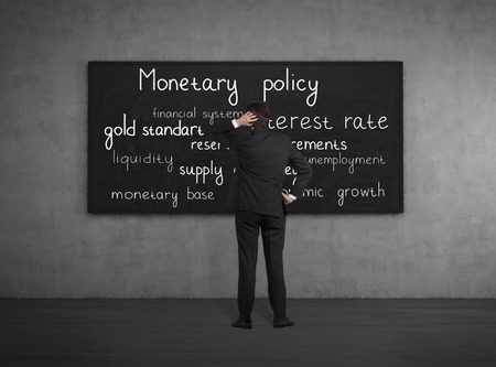 Businessman think about monetary policy at the blackboardの写真素材