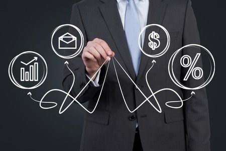 businessman holding business symbols with arrowsの写真素材