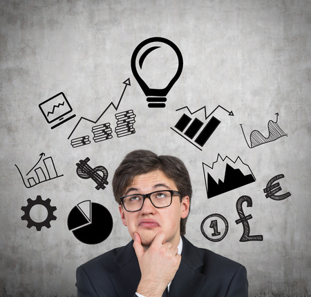 young businessman thinking and business icon over headの写真素材