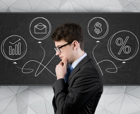 businessman thinking and business symbols with arrows drawing on deskの写真素材