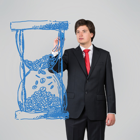 businessman drawing hourglass on a gray background