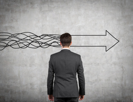 businessman standing and looking to drawing arrow on wallの写真素材