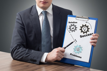 businessman in office holding clipboard with success conceptの写真素材